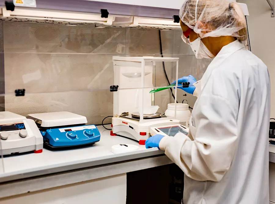 Kizer Wellness Pharmacy pharmacist compounding low dose naltrexone (LDN) under a USP-800 compliant hood with precision analytical balance